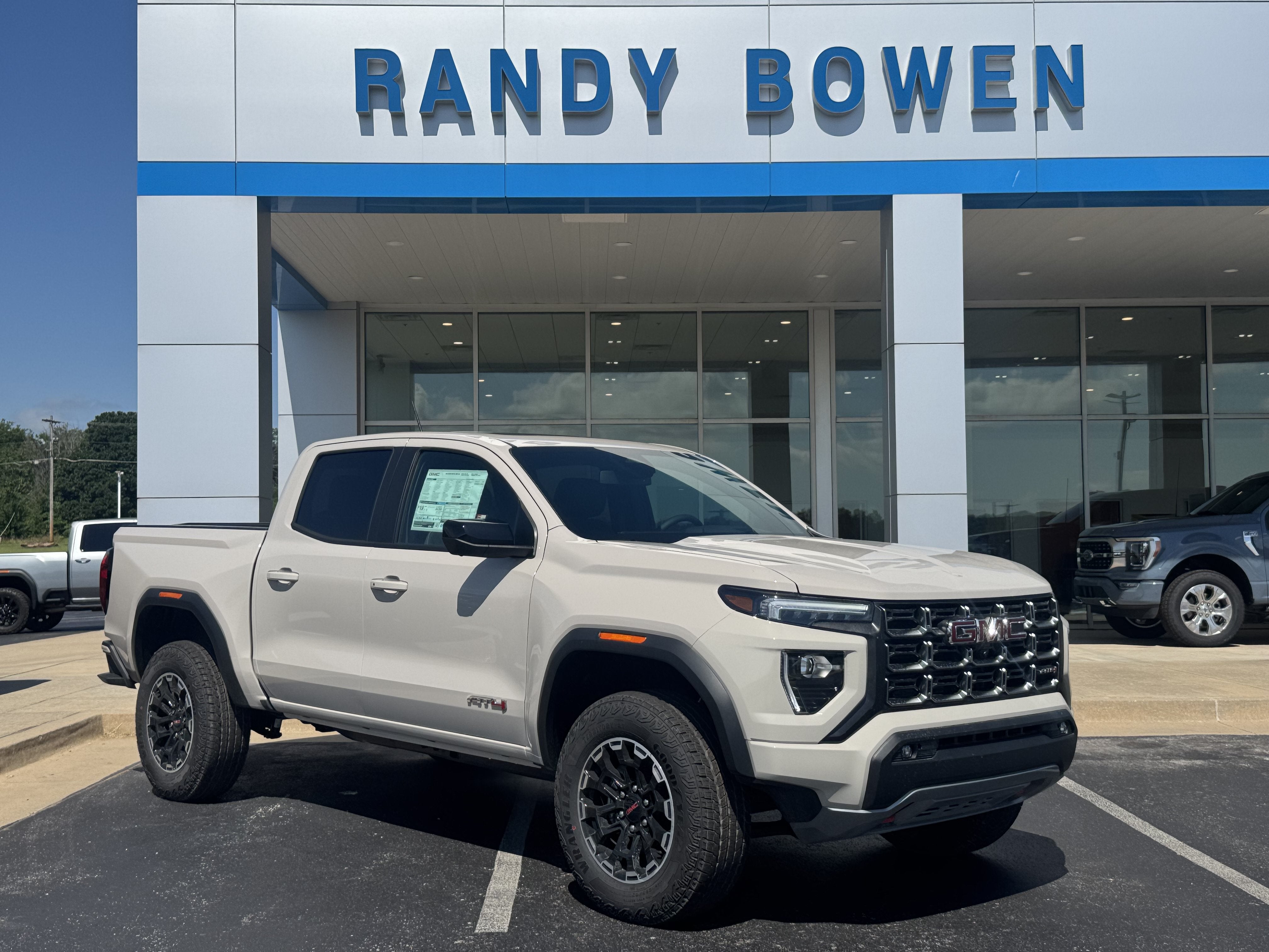 2026 GMC Canyon AT4 in Coastal Dune — front three-quarter view